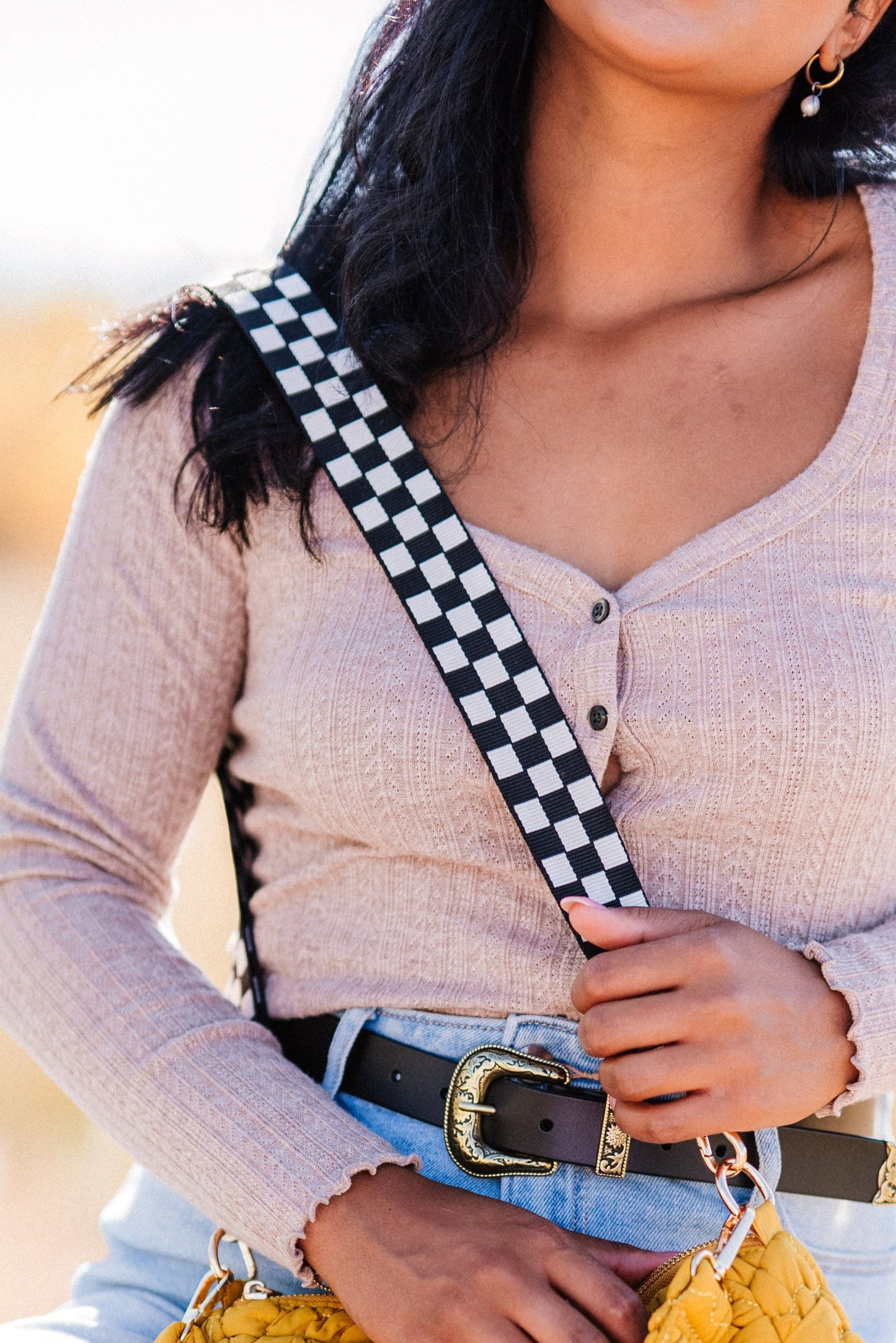 Woman is wearing a Black and white Modern + Chic Lizzie Checkered Purse Strap for Crossbody Bags. 