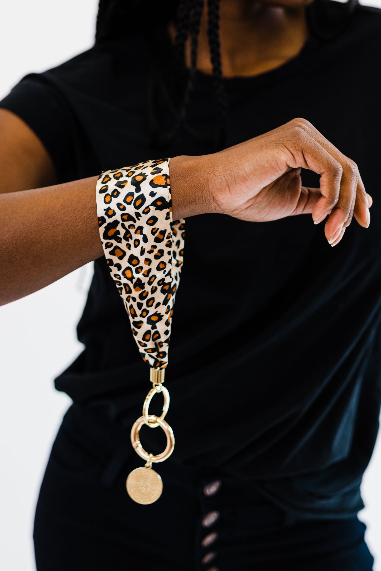 A woman wearing all black wearing a Modern + Chic Luna Fabric Keychain Bracelet for Women around her wrist.