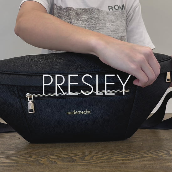 A woman showing the features and benefits of a Modern+Chic Presley Oversized Sling Bag for Women with gold hardware. 