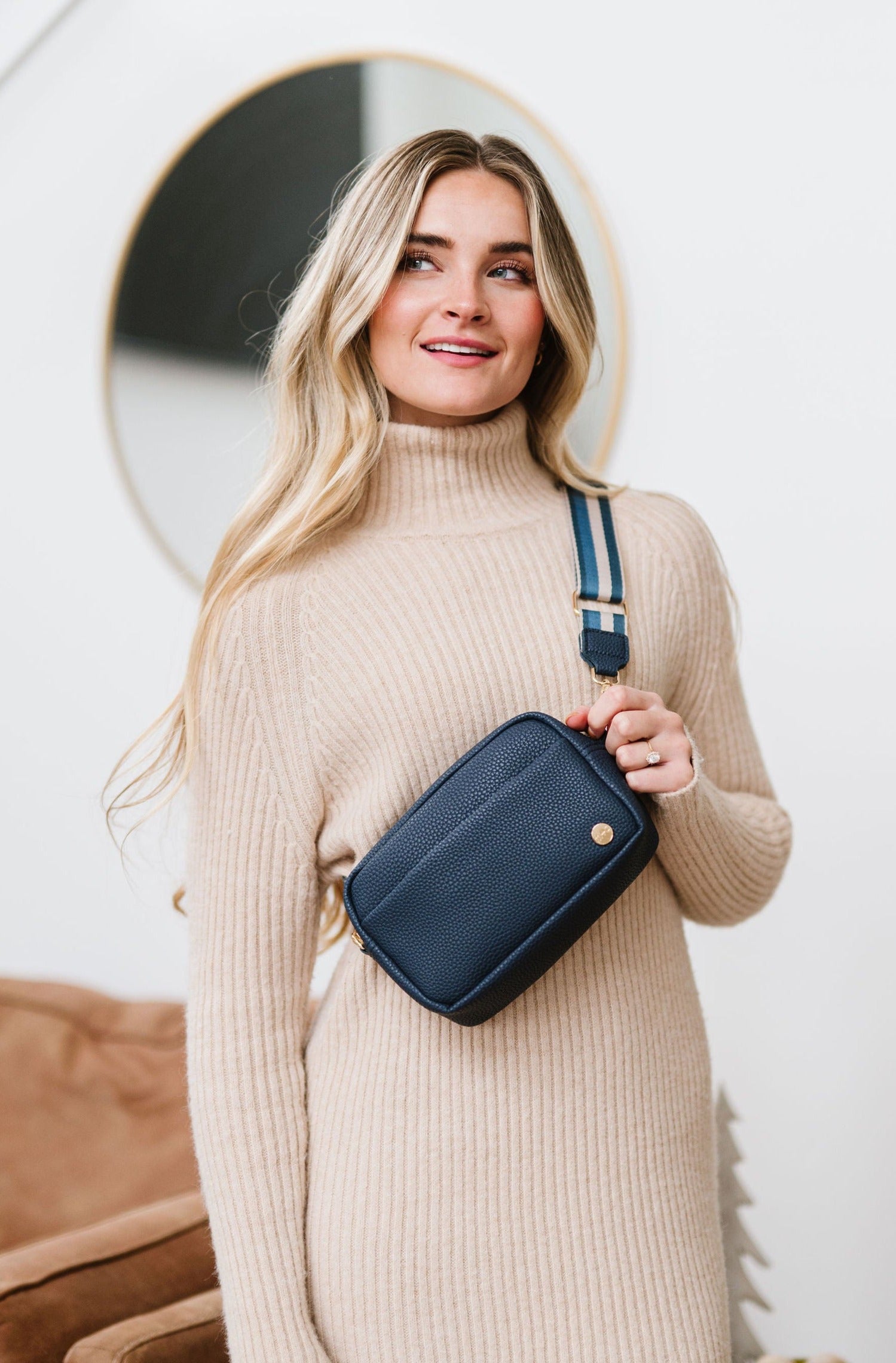Woman wearing a blue Modern+Chic Willow Vegan Leather Convertible Crossbody Bag on a white background. 